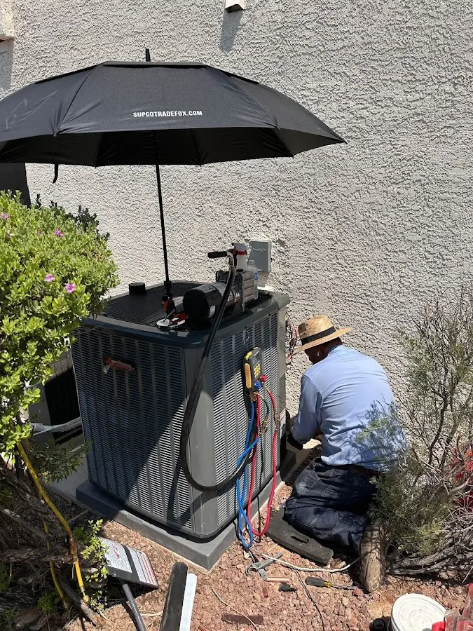 HVAC technician performing outdoor AC maintenance in Woodstock