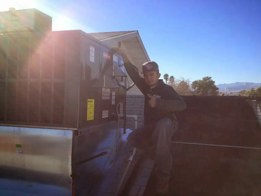 HVAC technician performing HVAC Inspection on a rooftop unit in Woodstock